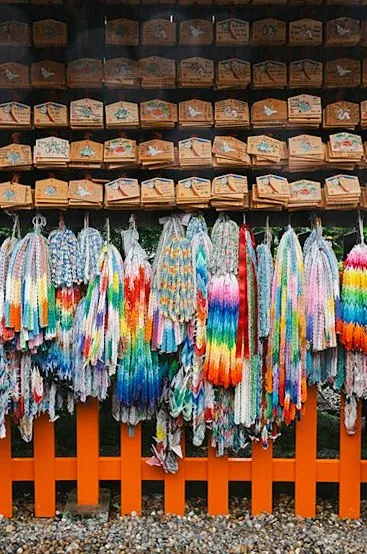 神社に奉納された絵馬と、色とりどりの折り鶴